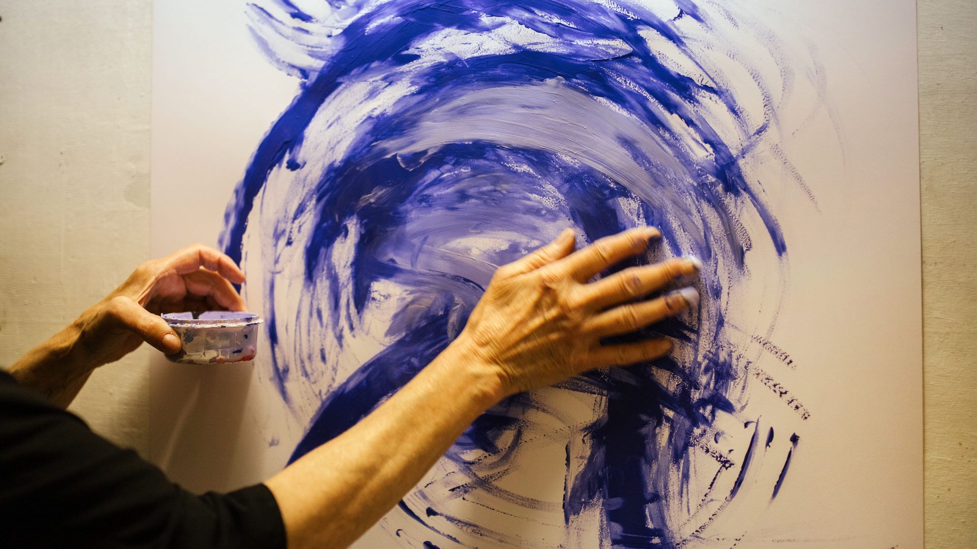 Hände auf Leinwand mit blauer Farbe 