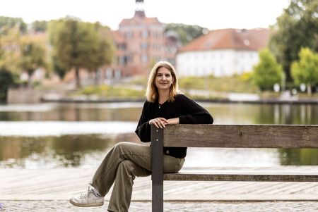 Lilli Reimansteiner sitzt auf einer Bank am Großen Eutiner See.