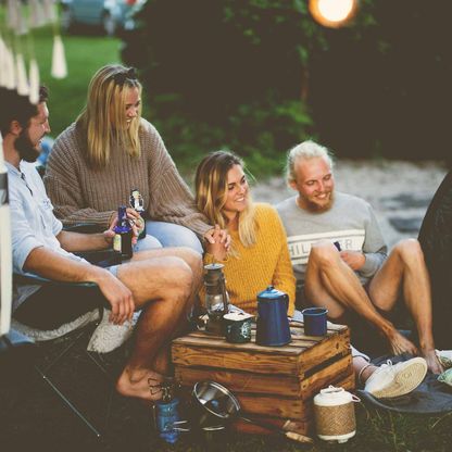 Camper sitzen vor ihren Bullis und unterhalten sich