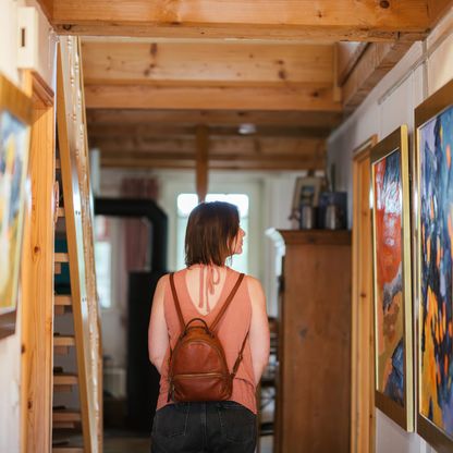 Frau sieht sich Bilder in Galerie an (von hinten fotografiert)